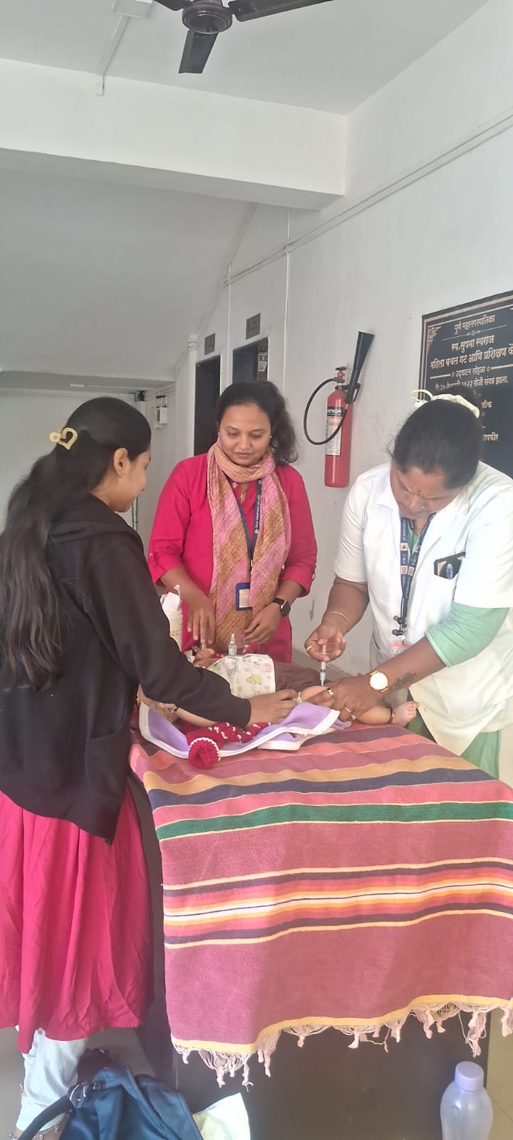 Nurses preparing a vaccine dose at a municipal women's training centre