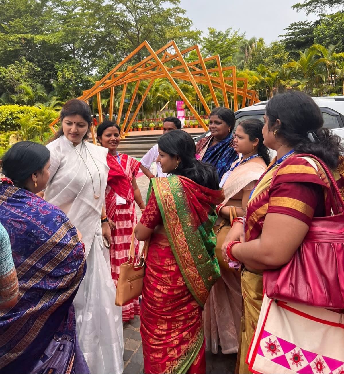 Group of women in sarees talking during a field visit