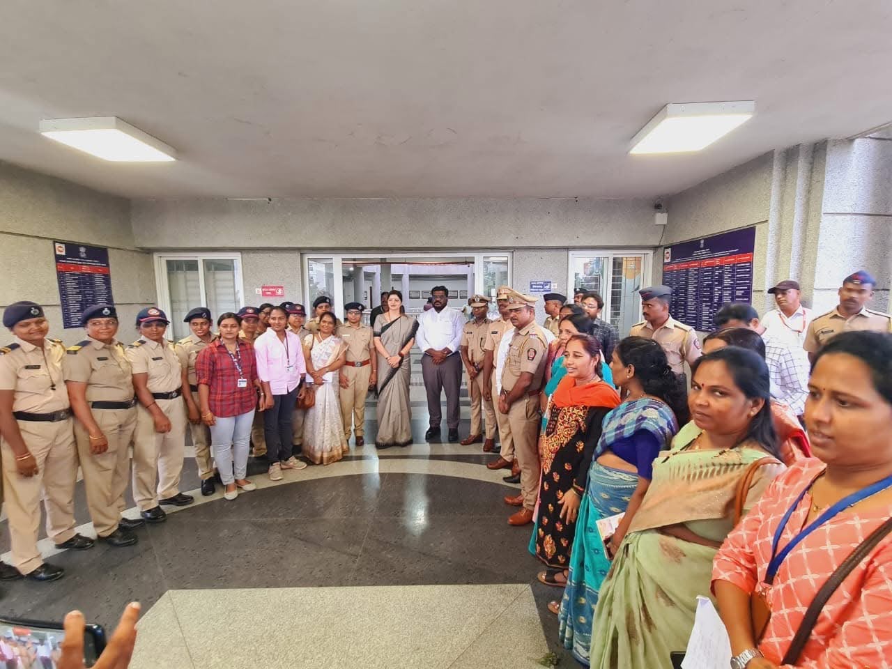Group photograph with women police officers and community members in a station lobby
