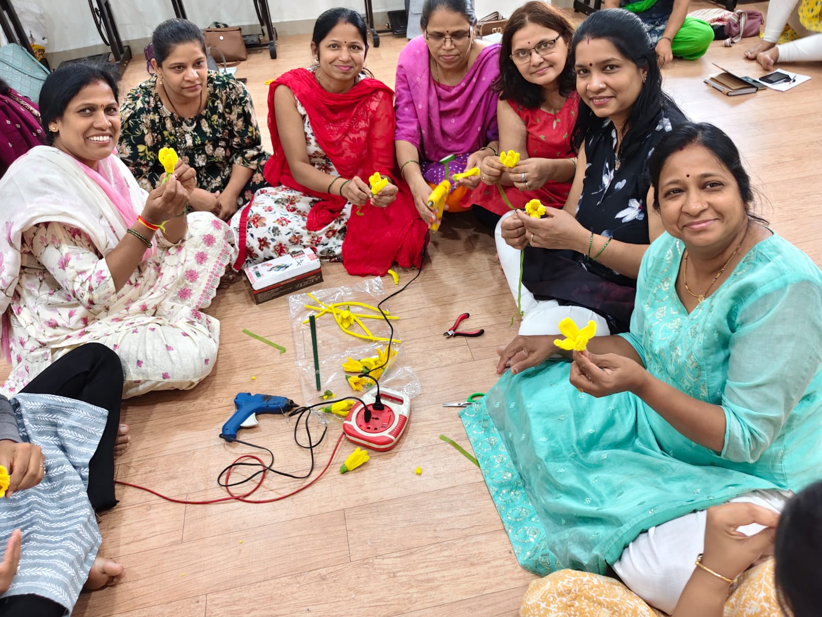 Women holding the flowers they made at a Krantijyot workshop in Pune