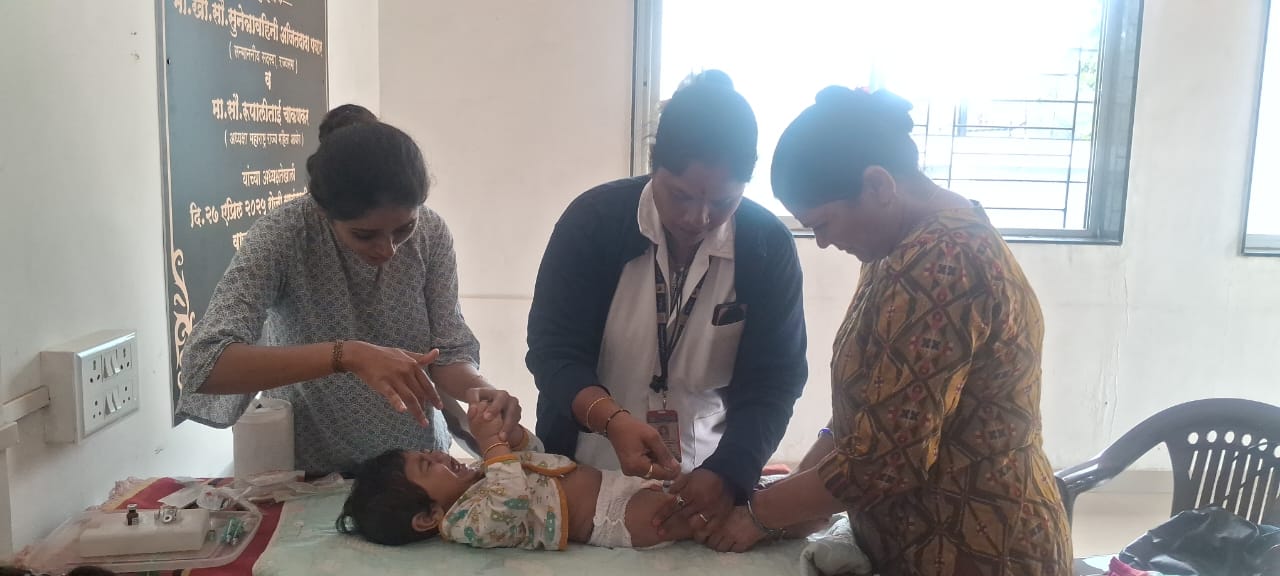 Three health workers examining a baby during a check-up