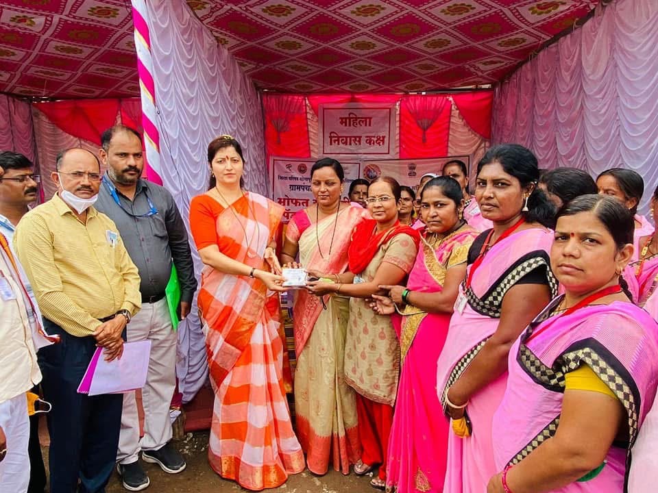 Women receiving free sanitary napkin kits at a village camp