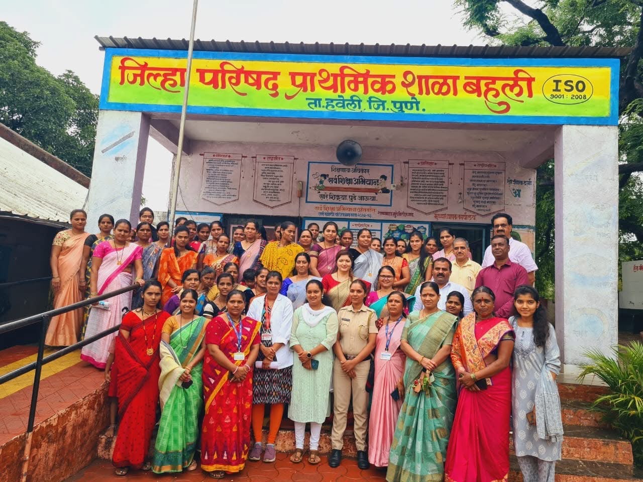 Large group photograph of women and officials outside a Zilla Parishad school near Pune